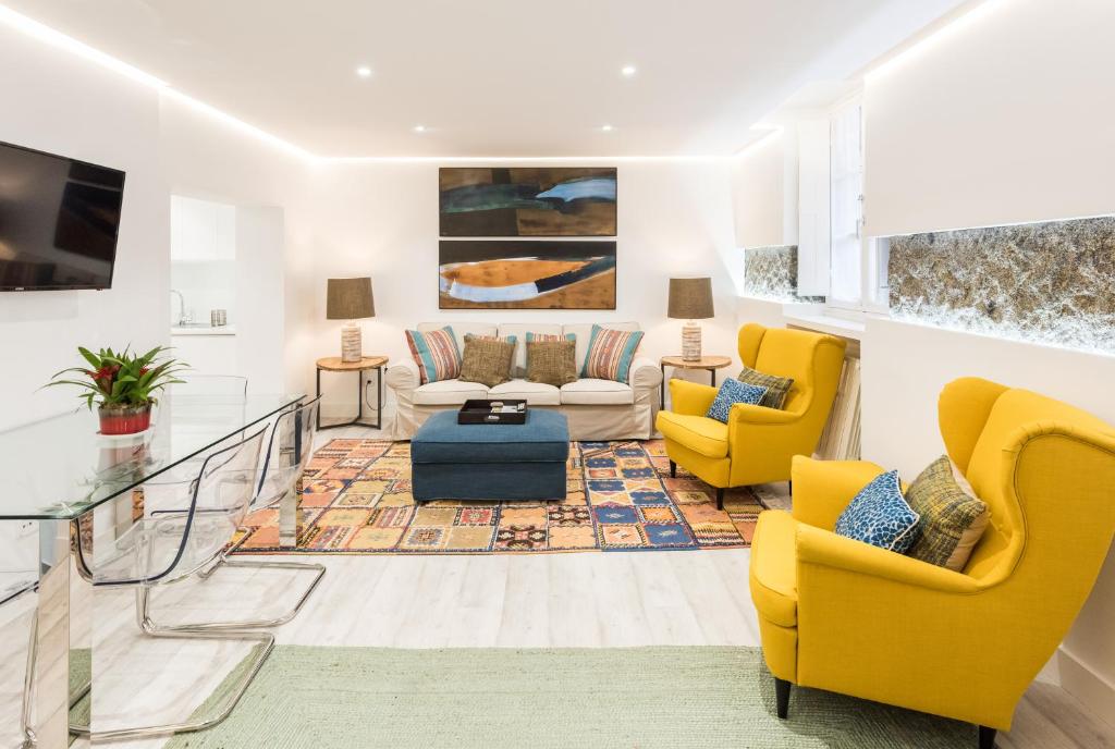 a living room with yellow chairs and a couch at Art & Design Gran Via in Madrid