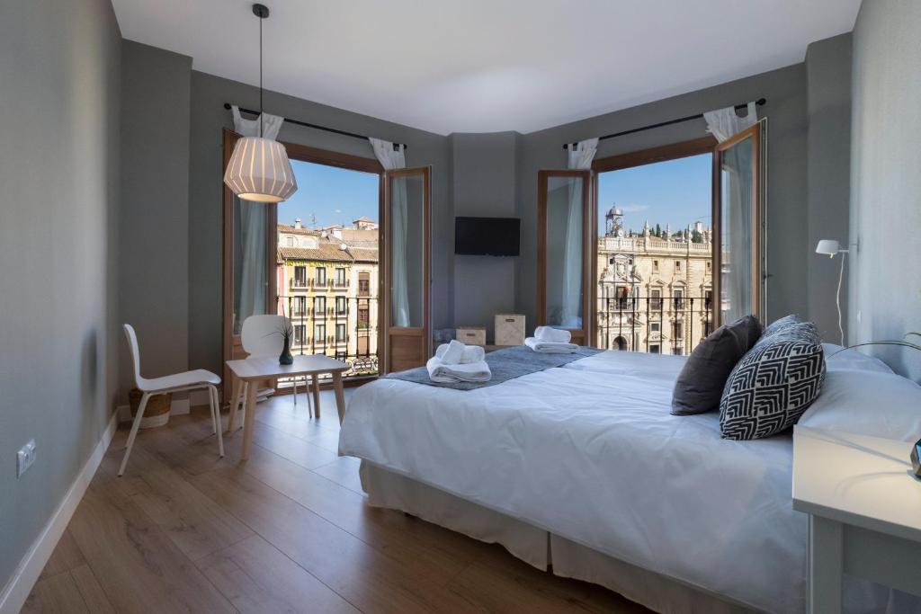 a bedroom with a large bed with a view of a building at Pension Boutique Gomerez Gallegos in Granada