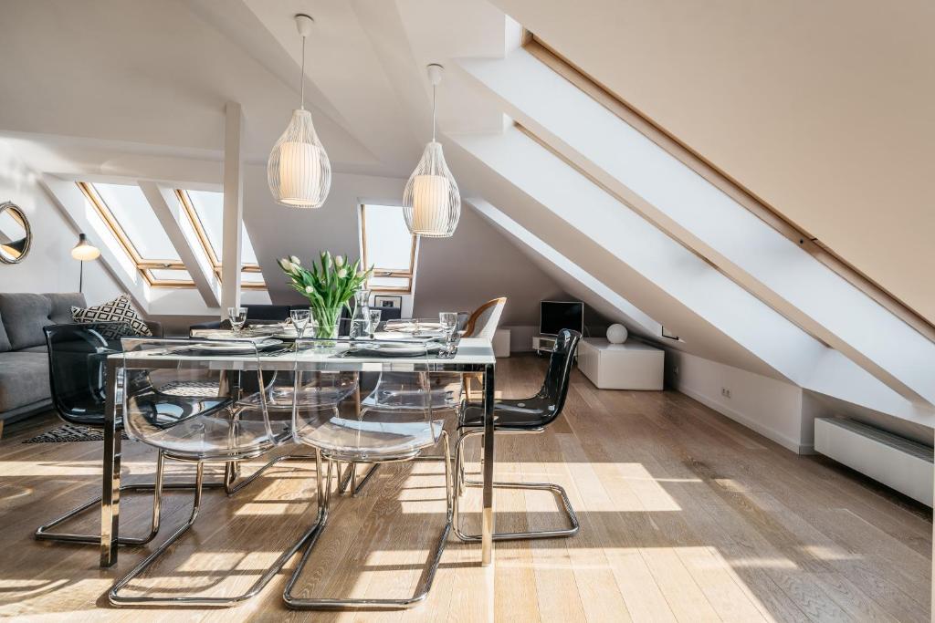 a dining room with a glass table and chairs at Penthouse Skyline by LoftAffair in Krakow