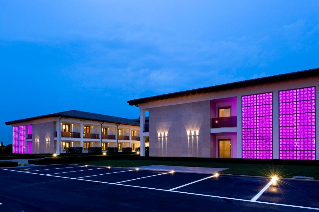 un edificio con luces púrpuras en un aparcamiento en Viola Mhotel, en Grumello del Monte