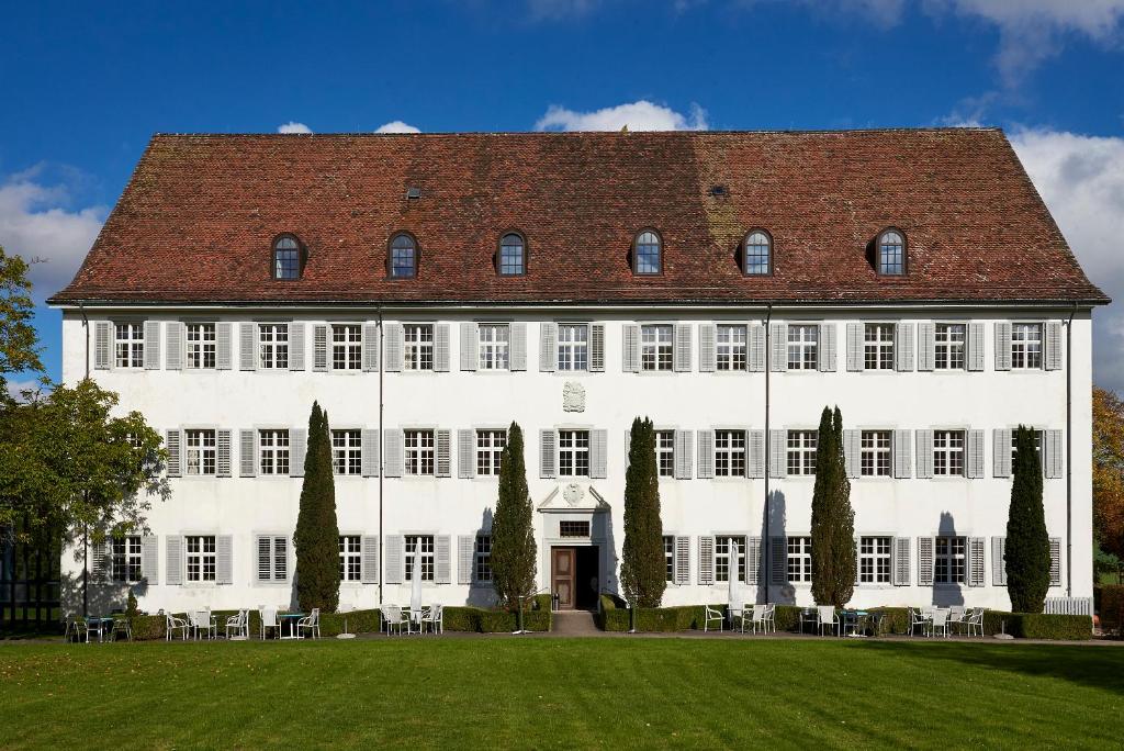 un gran edificio blanco con techo rojo en Klosterhotel Kreuz, en Mariastein