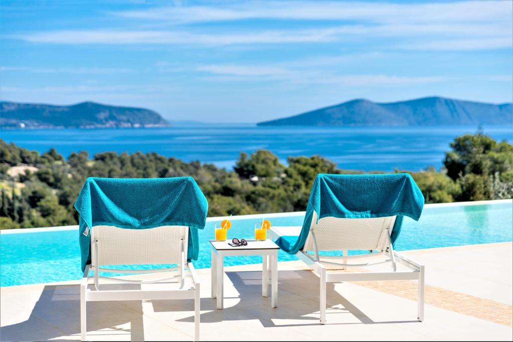 ポルト・ヘリにあるVilla Emmelia & Guesthouse Amazing View with Poolのスイミングプールの横に椅子2脚とテーブル1台