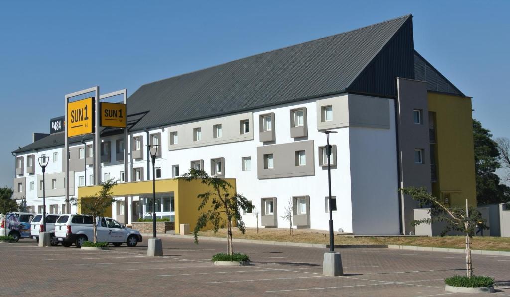 a large white building with a black roof at SUN1 WITBANK in eMalahleni
