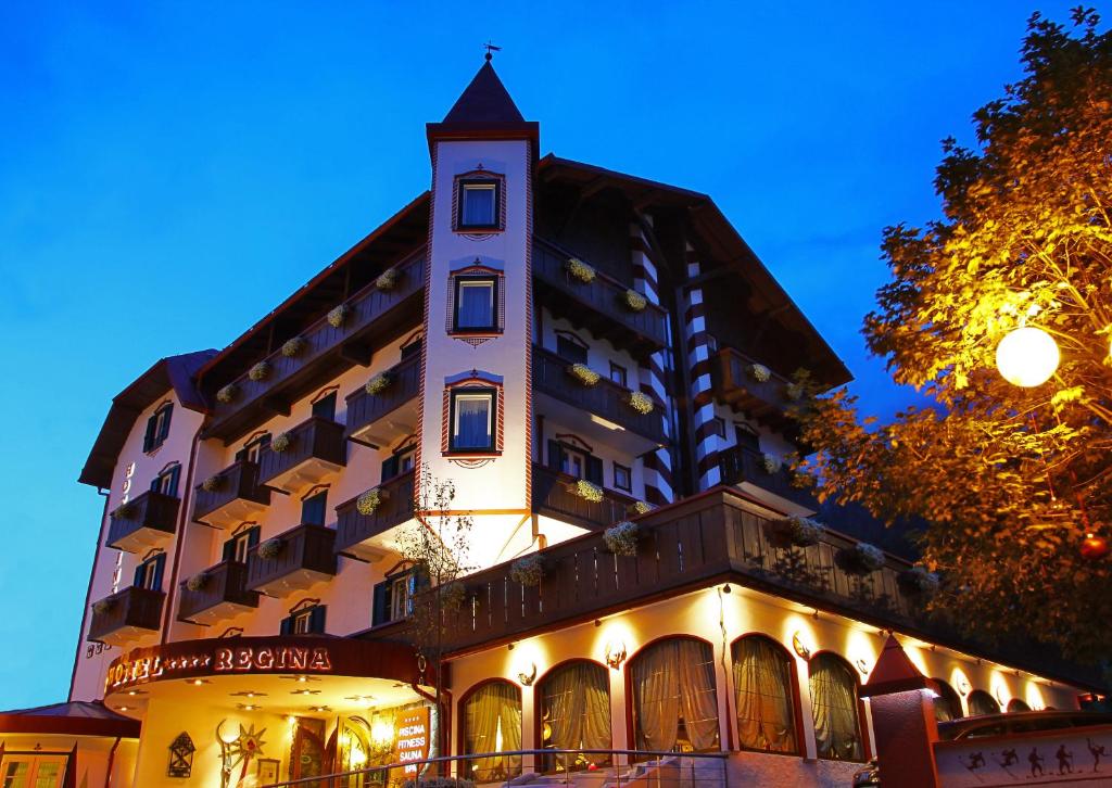 a large building with a clock on the front of it at Hotel Regina in San Martino di Castrozza