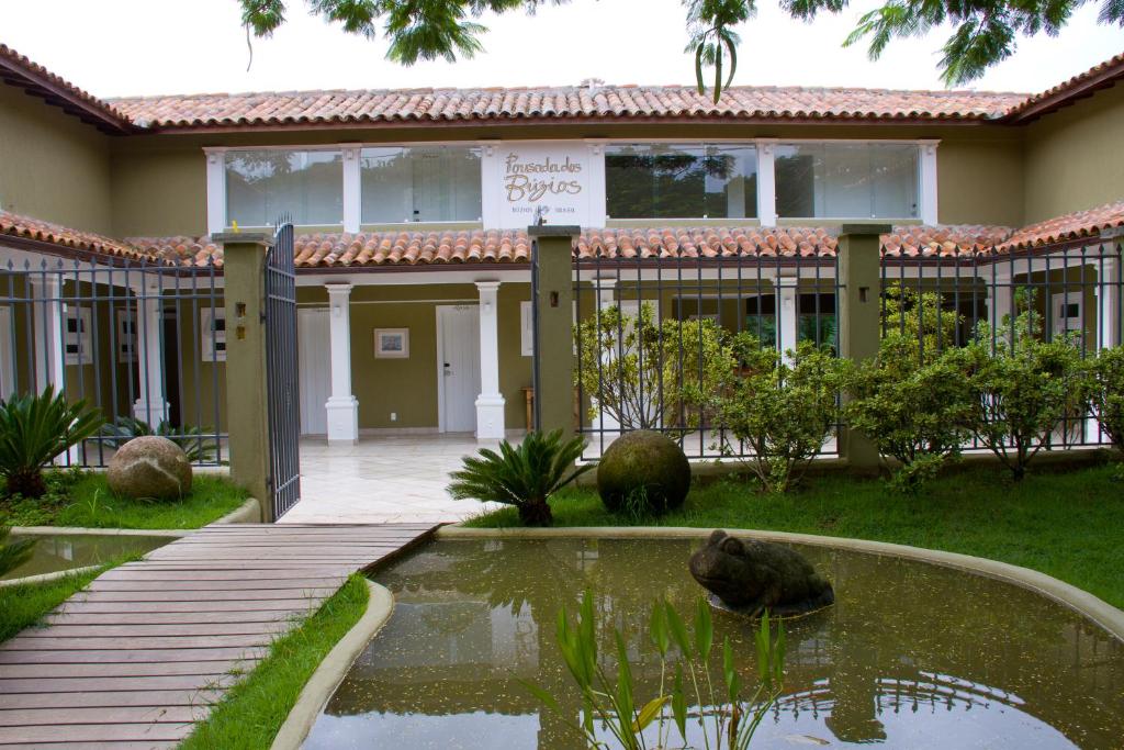 une maison avec un étang en face de celle-ci dans l'établissement Pousada Dos Búzios, à Búzios