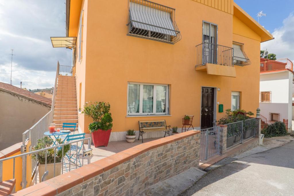 a yellow house with a balcony and a patio at Casa Linda, a due passi dal mare in Numana