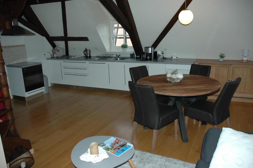 a kitchen and living room with a wooden table and chairs at appartement à Colmar in Colmar