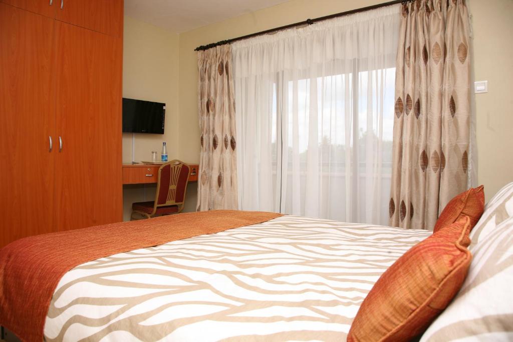 Postel nebo postele na pokoji v ubytování Nairobi Transit Hotel