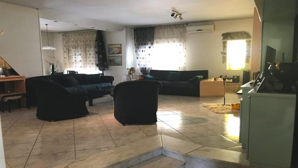 una sala de estar con sofás y una sala de estar con en Friendly Family House, en Volos