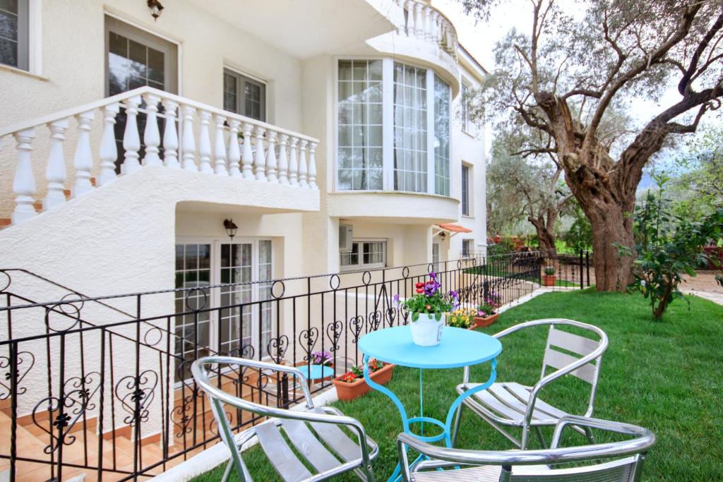a patio with chairs and a table in front of a house at The Olive Garden in Limenas