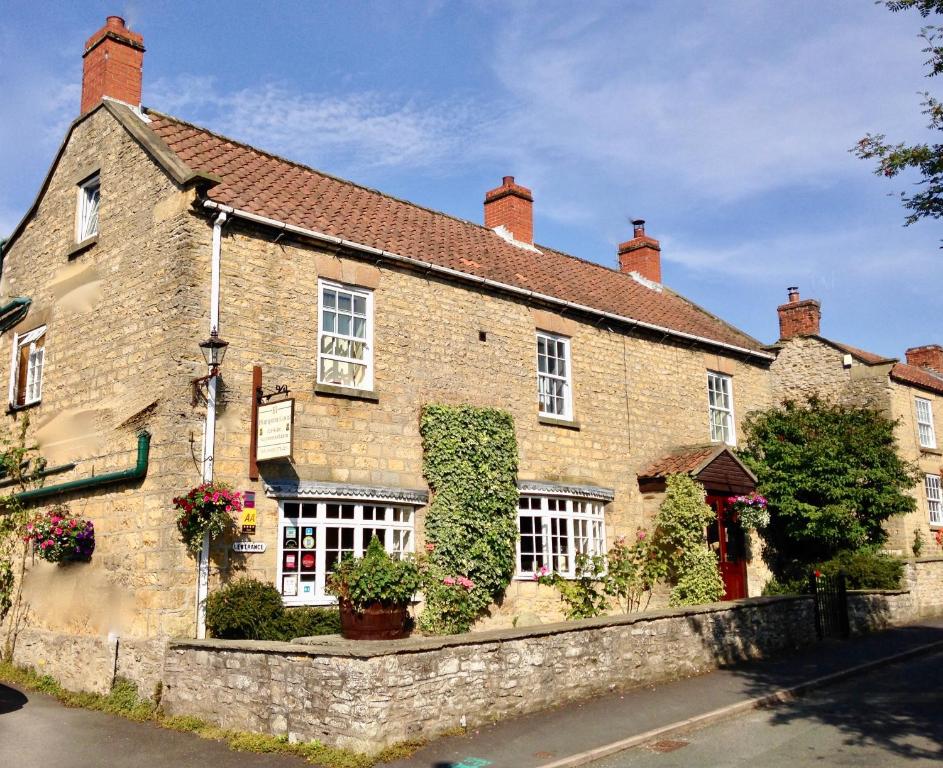 - un vieux bâtiment en briques avec du lierre dans l'établissement Plumpton Court, à Nawton