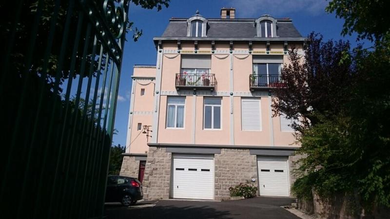 ein großes rosafarbenes Gebäude mit zwei weißen Garagentüren in der Unterkunft Demeure des Dentelles in Le Puy en Velay