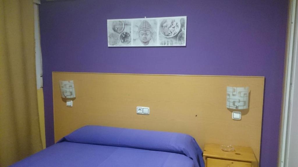 Cette chambre comprend un lit violet et jaune. dans l'établissement Hostal DS, à Velilla de San Antonio