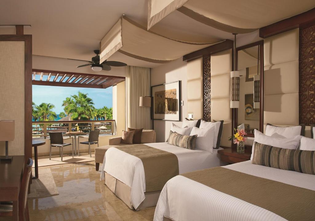 a hotel room with two beds and a balcony at Secrets Playa Mujeres Golf & Spa Resort - All Inclusive Adults Only in Cancún