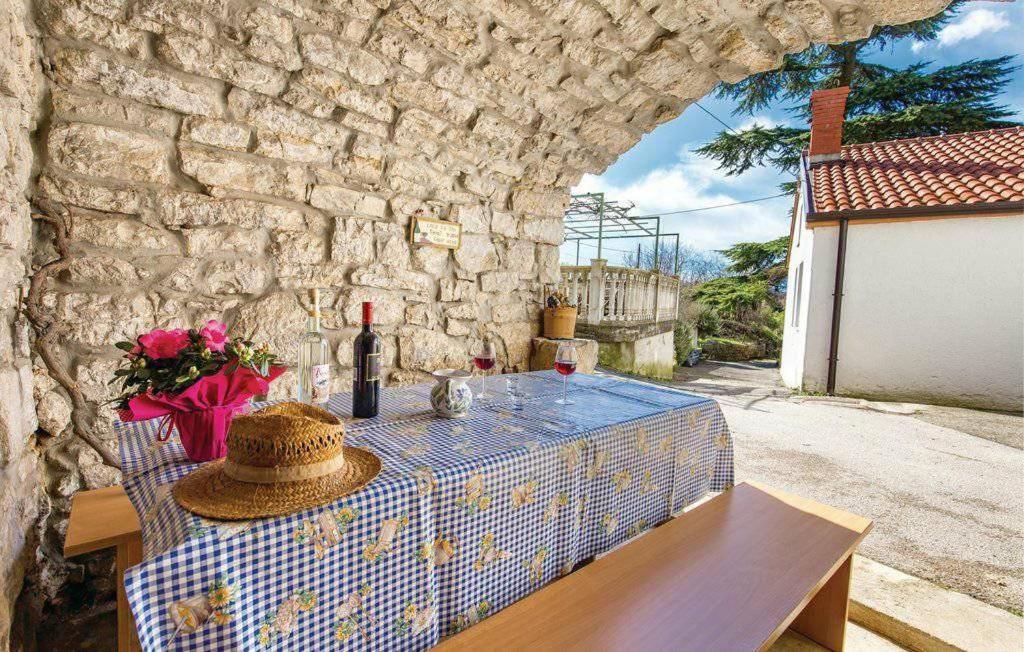 a table with a bottle of wine and a hat at Holiday Home Marica in Kastav