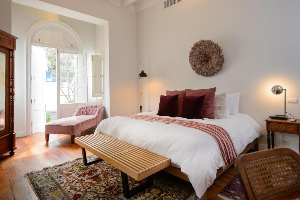 利馬的住宿－Villa Barranco by Ananay Hotels，一间卧室配有一张大床和一把椅子