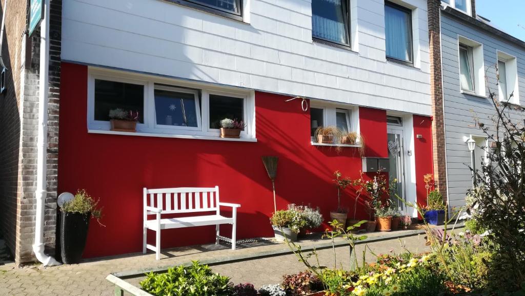 ein rotes und weißes Haus mit einer Bank davor in der Unterkunft Haus Nautilus in Helgoland