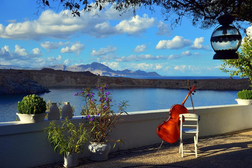 une chambre avec des plantes et une vue sur l'eau dans l'établissement Villa Melenos Lindos, à Lindos