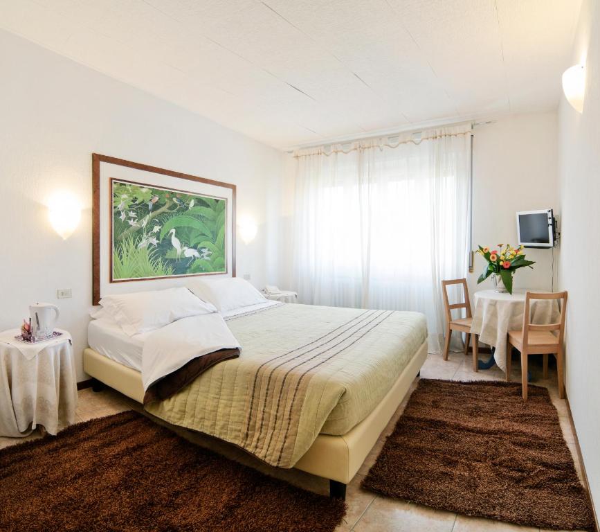 レニャーノにあるAntico Albergo Madonnaのベッドルーム1室(ベッド1台、テーブル、椅子付)