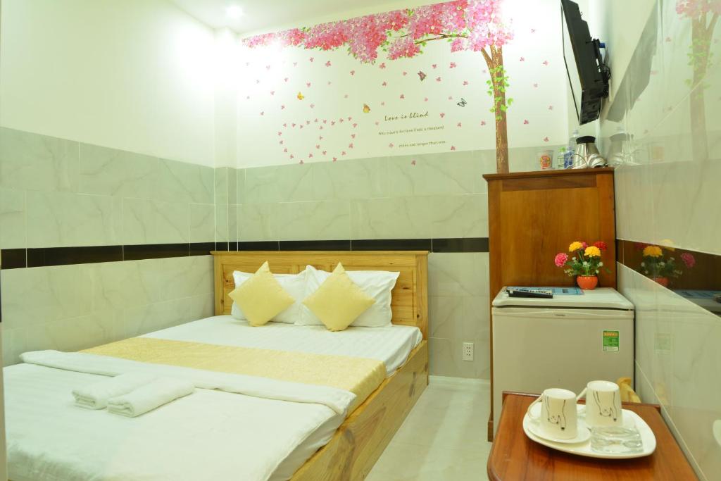 Cette petite chambre comprend un lit et une table avec des tasses. dans l'établissement Hoang Chau Motel, à Vung Tau