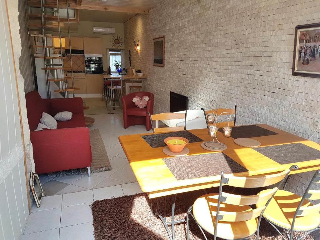 ein Wohnzimmer mit einem Holztisch und Stühlen in der Unterkunft Maison Arles in Arles
