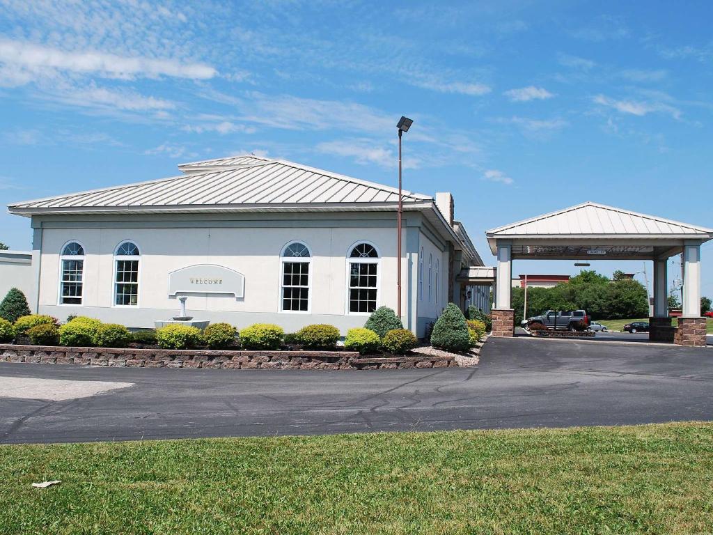 a white building with a gazebo in a parking lot at Travelodge by Wyndham Watertown in Watertown