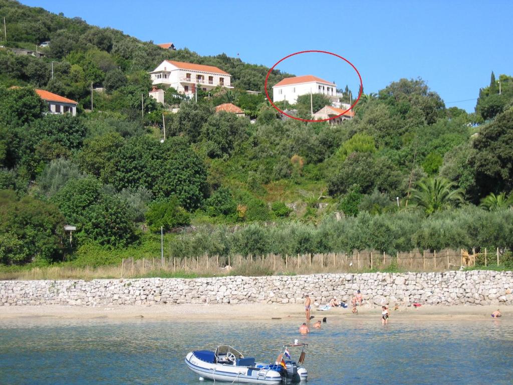 um barco na água com pessoas em uma praia em Diving Apartments em Molunat