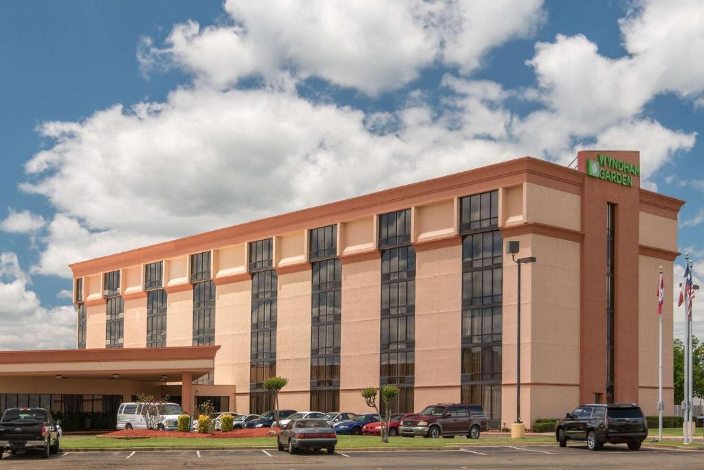 een hotelgebouw met auto's geparkeerd op een parkeerplaats bij Wyndham Garden Texarkana in Texarkana - Texas