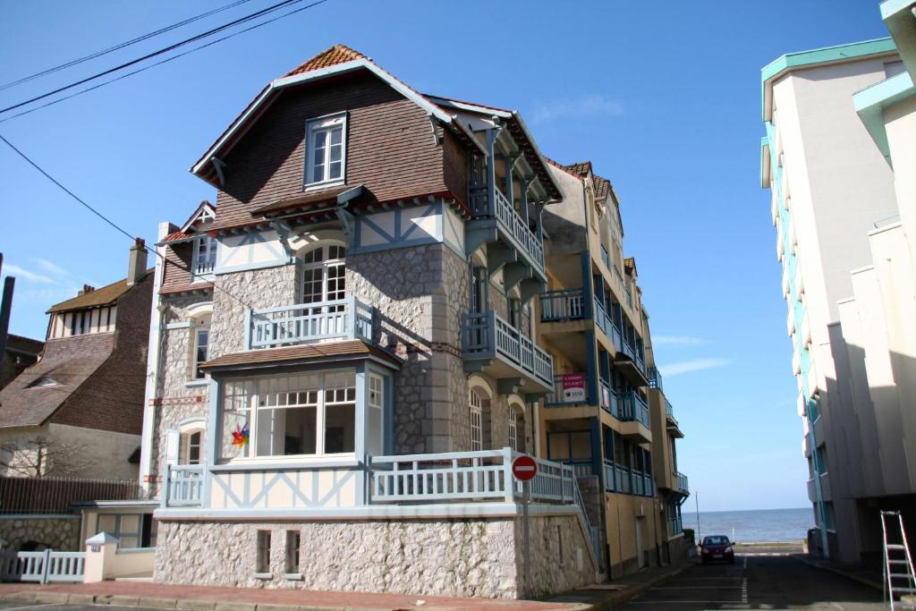 an old house with a balcony on a street at Villa Touquettoise et Cape Cod in Le Touquet-Paris-Plage