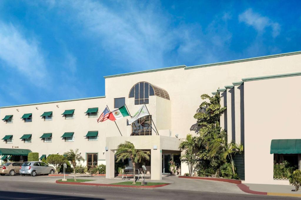 a large white building with flags in front of it at Wyndham Garden Obregon in Ciudad Obreg&oacute;n