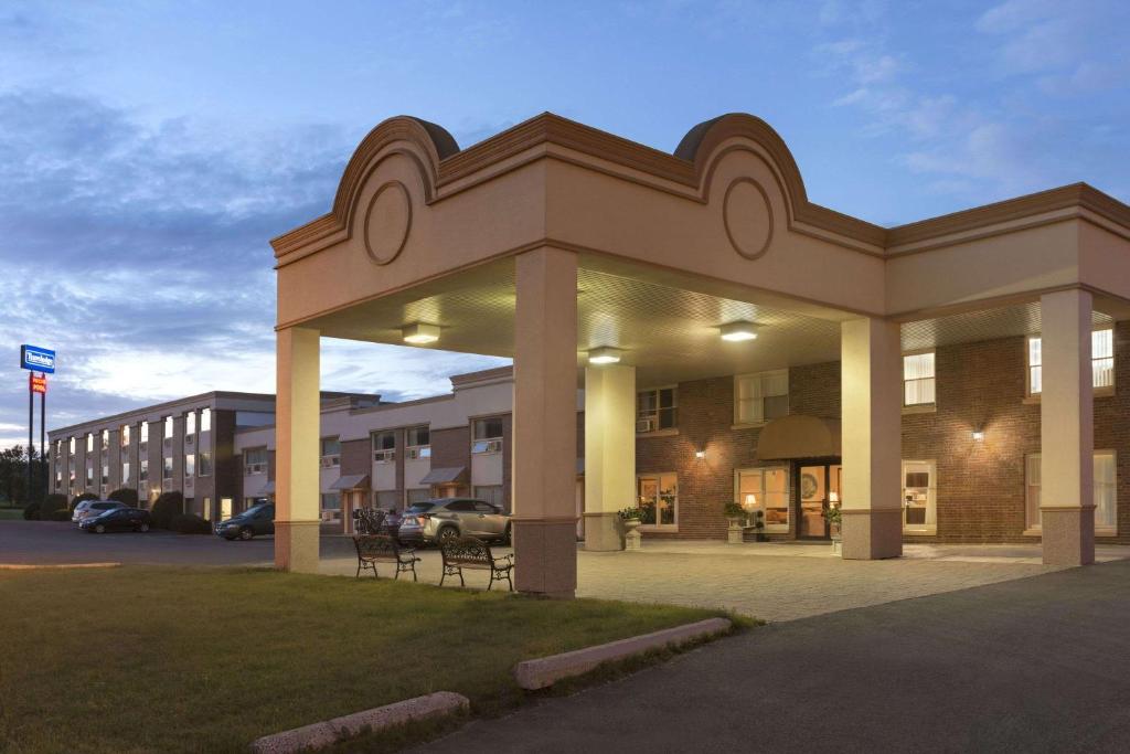 a large building with a parking lot in front of it at Travelodge by Wyndham Edmundston in Edmundston