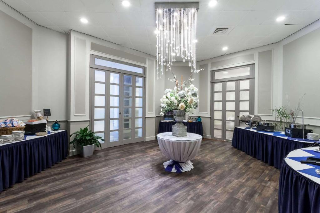 a large room with a table with flowers on it at Wyndham Southbury in Southbury
