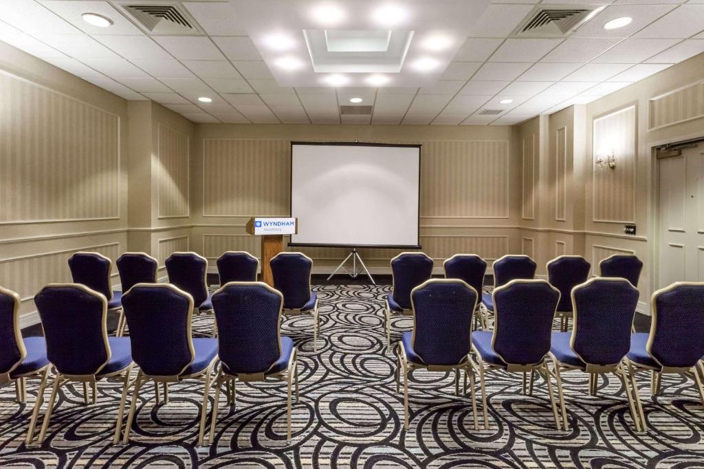 a conference room with chairs and a white screen at Wyndham Southbury in Southbury