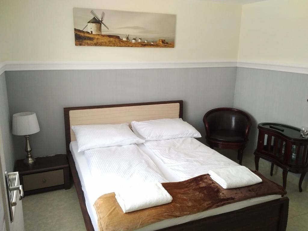 チェンストホヴァにあるDom Jurajskiのベッド(白いシーツ、風車付き枕付)