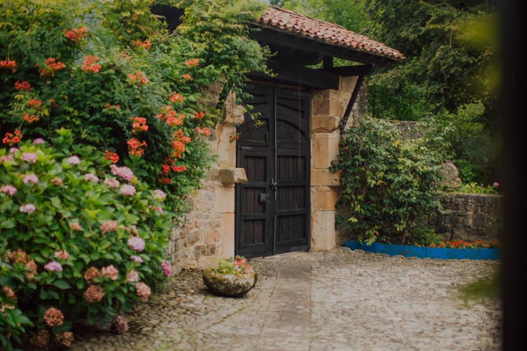 una entrada a una casa con una puerta y flores en Remanso del río Saja, en Renedo