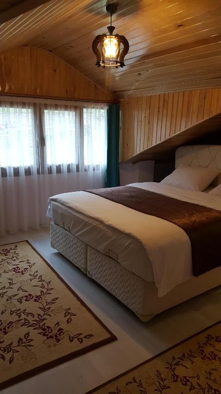 a bedroom with a large bed with a wooden ceiling at Ozbek Suite Hotel in Uzungol