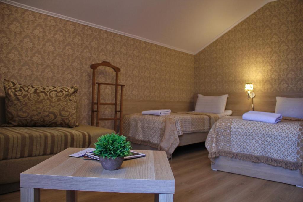 una camera con due letti, un tavolo e un divano di Lavitor hotel a Bishkek