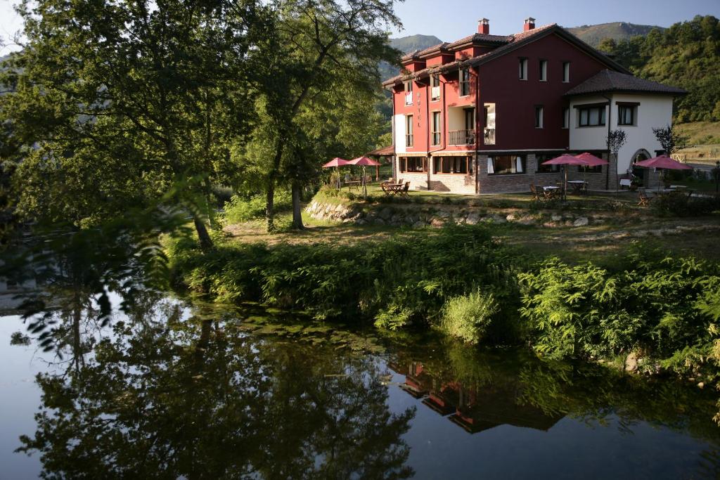 una casa junto a un cuerpo de agua en Hotel Rural Casa de Campo, en Soto de Cangas