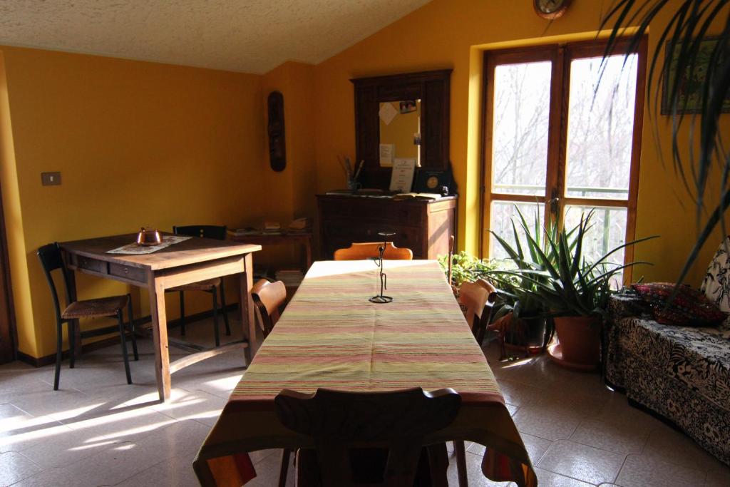 a living room with a wooden table and a table and a window at B&B Pian Savin in Giaveno