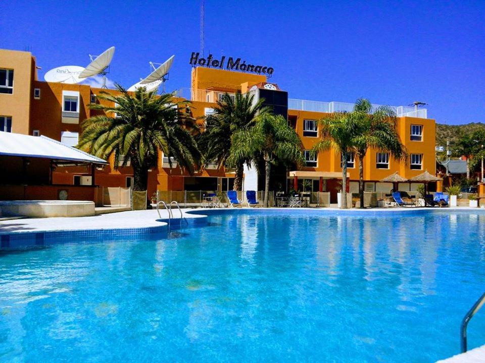 a large swimming pool in front of a hotel at Hotel Mónaco in Villa Carlos Paz