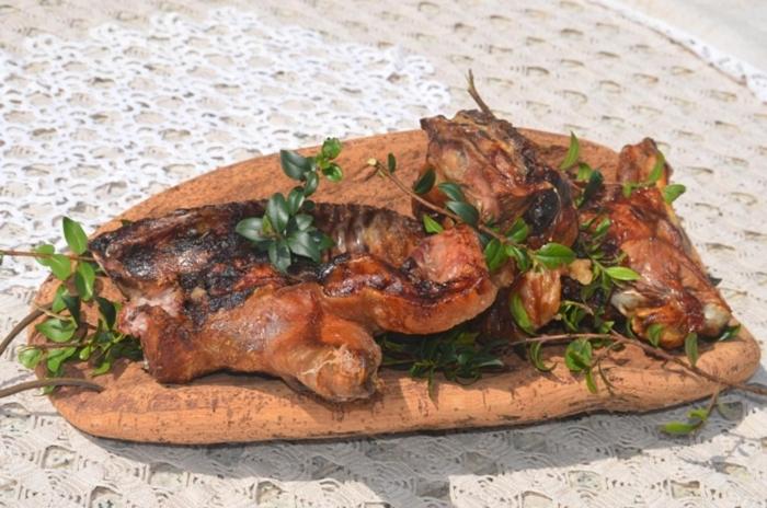 un pollo en una tabla con verduras en ella en Agriturismo Marongiu en Villaputzu