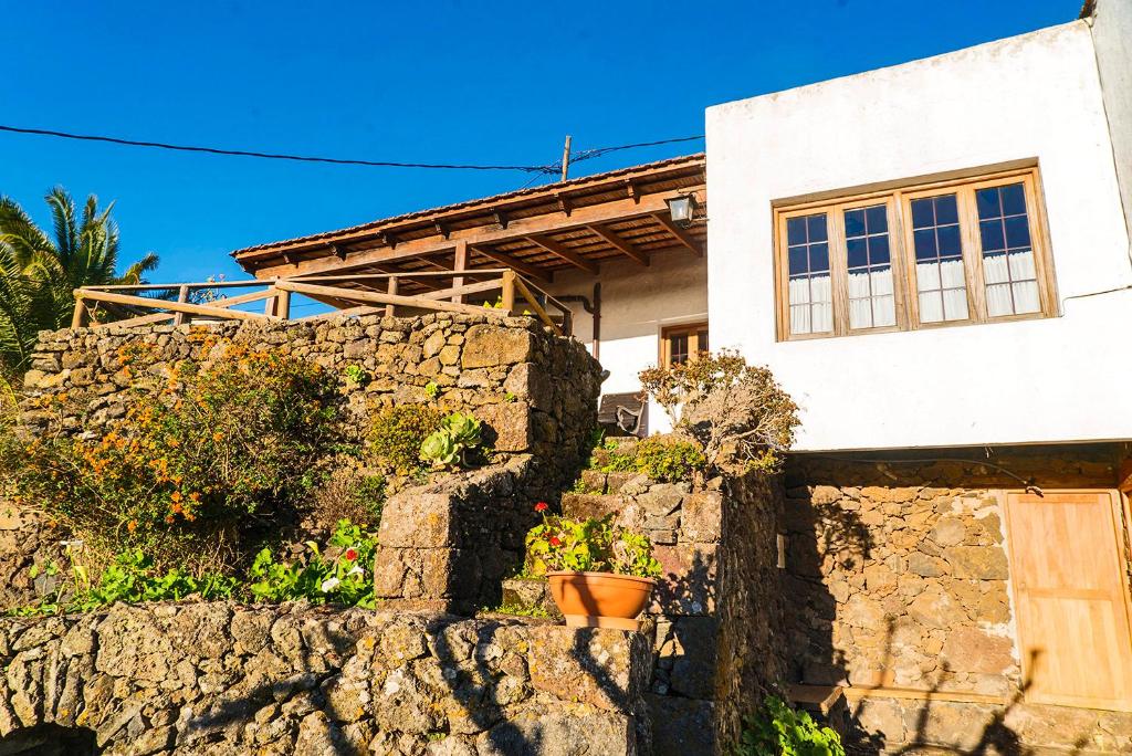 una casa in cima a un muro di pietra di Geranios Rojos a Las Rosas