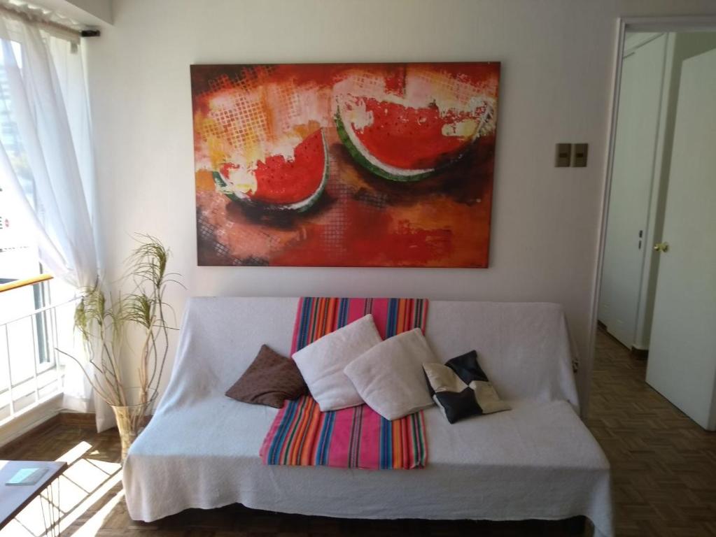 un sofá blanco en una habitación con una pintura en la pared en Apartamento cerca del mar en Viña del mar, en Viña del Mar