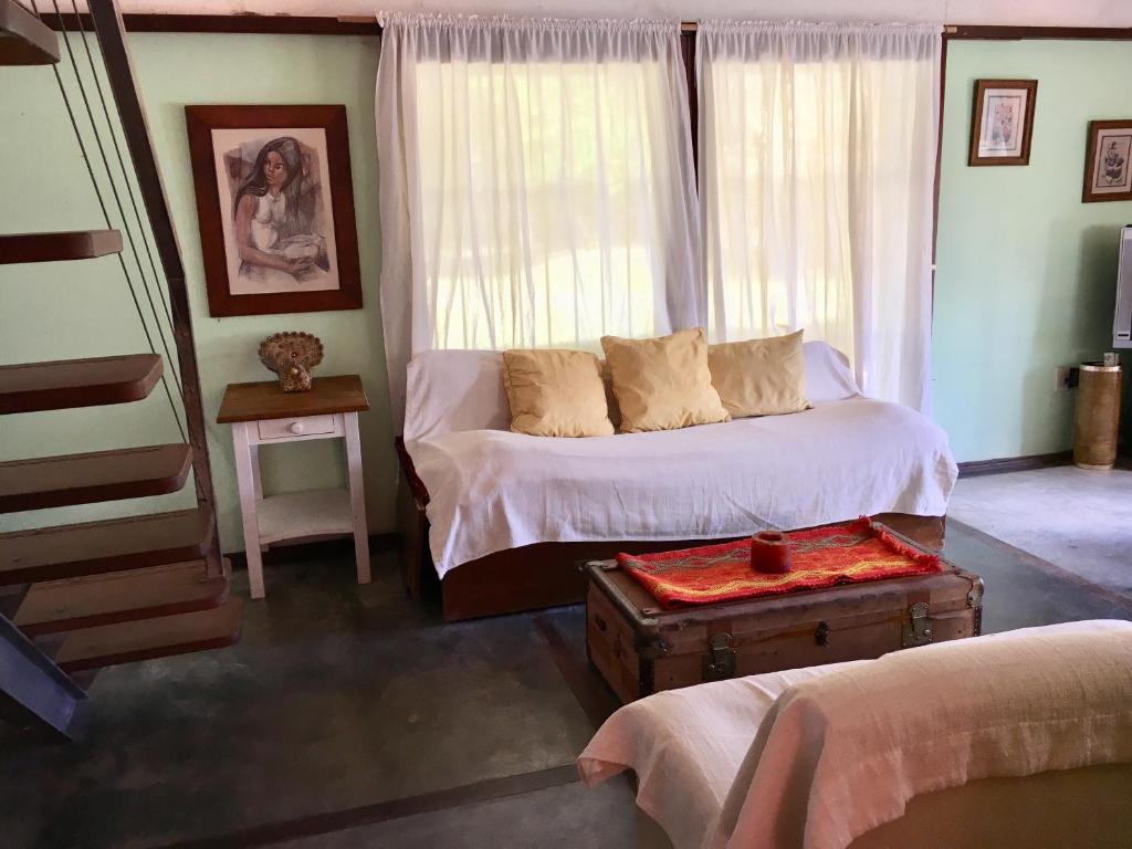 a bedroom with a bed and a table and a window at Casa en colonia para 7 personas in Colonia del Sacramento