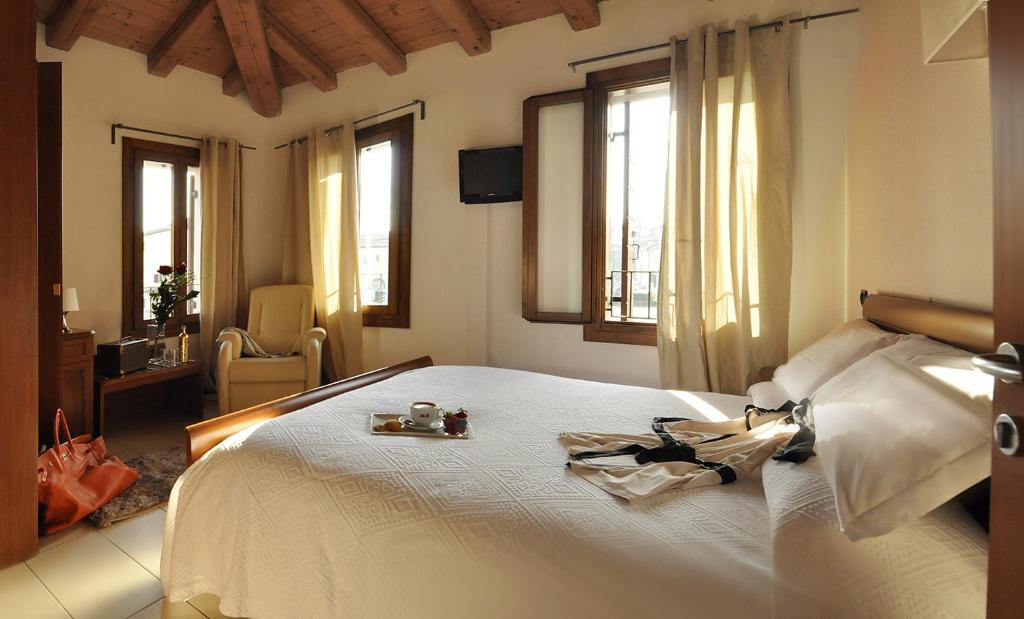 a bedroom with a white bed with a tray of food on it at La Rotonda Relais in Badoere