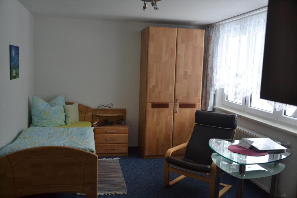 ein Schlafzimmer mit einem Bett, einem Stuhl und einem Tisch in der Unterkunft Haus Monika in Todtmoos