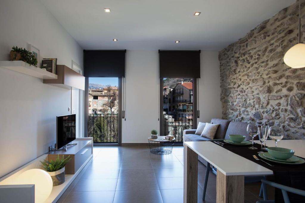 cocina y sala de estar con pared de piedra en Raval de Ripoll, en Ripoll