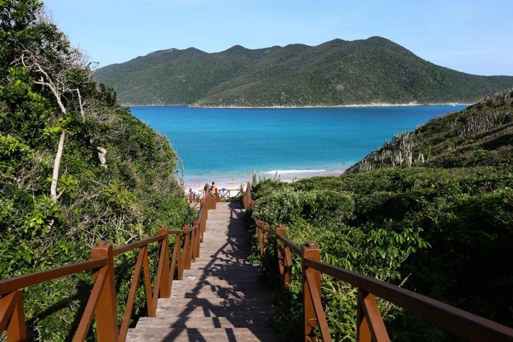 uma escada que leva a uma praia com o oceano em Apartamentos no centro em Arraial do Cabo