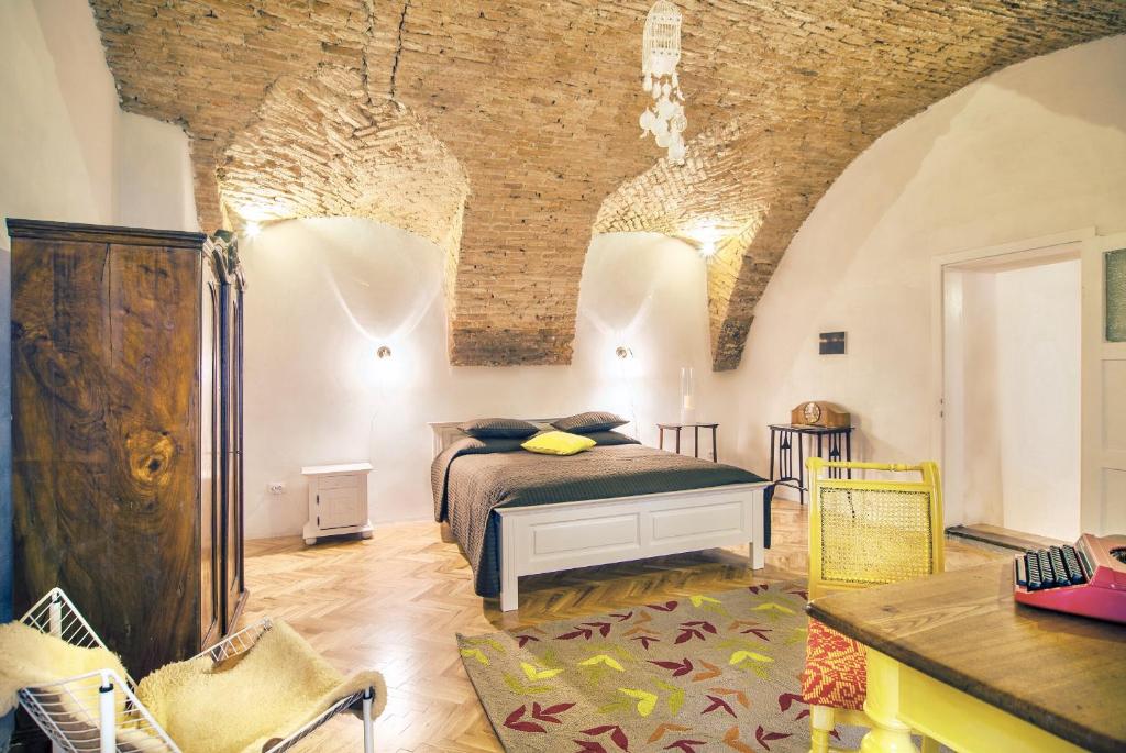 um quarto com uma cama e uma parede de tijolos em Cluj Apartments em Cluj-Napoca
