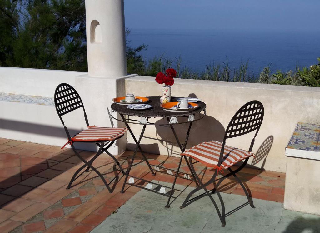 stół z 2 krzesłami i stół z jedzeniem w obiekcie Agriturismo La Dolce Vita Lipari w mieście Lipari